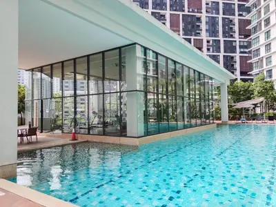 a large building with a pool in front of it at Ooak Suites Mont Kiara Mall 163 Babycot 4 Pax in Kuala Lumpur