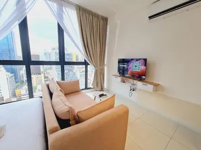a living room with a couch and a tv at Majestic Residence KLCC By AMG in Kuala Lumpur