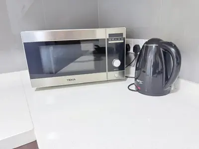 a microwave sitting on a counter next to a tea kettle at Agile Bukit Bintang By AR in Kuala Lumpur