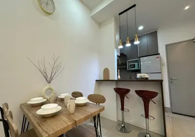 a kitchen and dining room with a wooden table and stools at K&L Suites Razak City Kuala Lumpur in Kuala Lumpur