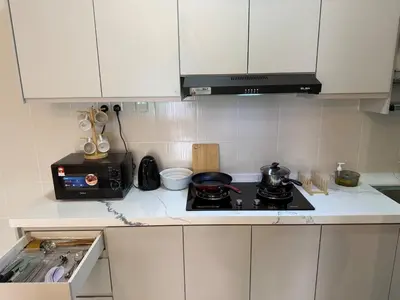 a kitchen with a stove and a microwave at K&L Suites Razak City Kuala Lumpur in Kuala Lumpur
