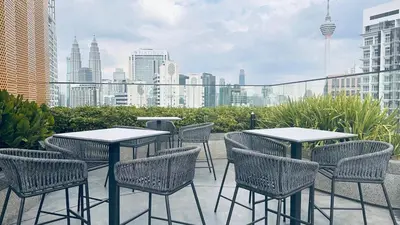 a patio with tables and chairs and a city skyline at Luxury studio 2607B for couple Majestic Residence KLCC in Kuala Lumpur