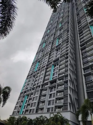 a tall building with palm trees in front of it at Trion Residence Kuala Lumpur by Centrix in Kuala Lumpur