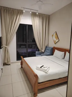 a bedroom with a bed and a blue chair at Trion Residence Kuala Lumpur by Centrix in Kuala Lumpur