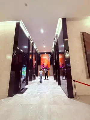 a woman walking down a hallway in a building at Platinum Suites Kuala Lumpur BY NOVA in Kuala Lumpur