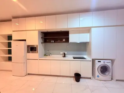 a kitchen with white cabinets and a washing machine at Platinum Suites Kuala Lumpur BY NOVA in Kuala Lumpur
