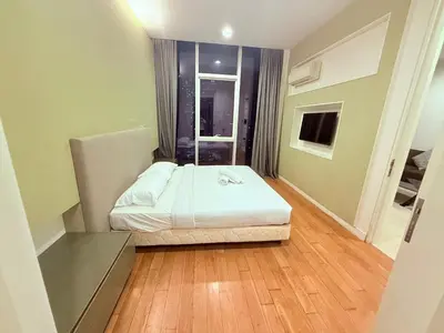 a small bedroom with a bed and a wooden floor at Platinum Suites Kuala Lumpur BY NOVA in Kuala Lumpur