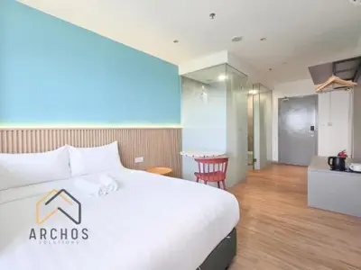 a hotel room with a white bed and a table at Riveria city in Kuala Lumpur