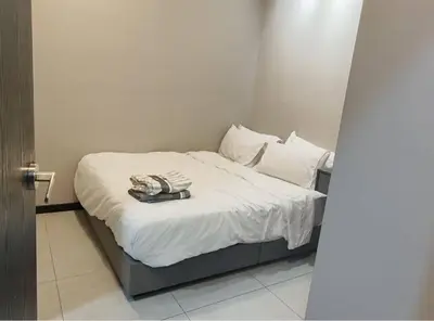 a bed with white sheets and a phone on it at Mini studio with own private bathroom, free Wi-Fi in Kuala Lumpur
