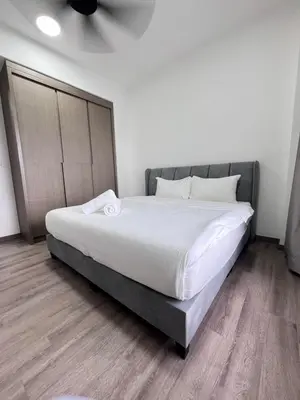 a bedroom with a large bed with white sheets at Sky Line Agile Suites KL in Kuala Lumpur