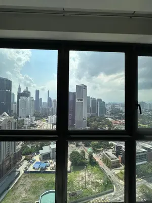 a view of a city skyline from a window at Sky Line Agile Suites KL in Kuala Lumpur
