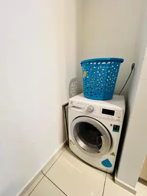 a washing machine with a blue basket on top of it at FA Suits KL BY ROBERTSON in Kuala Lumpur