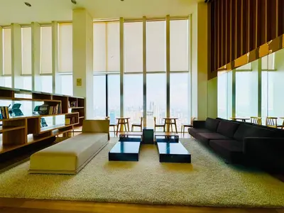 a living room with a couch and tables and large windows at The platinum KLCC by suites hospitality in Kuala Lumpur