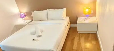 a bedroom with a white bed with a cross on it at The platinum KLCC by suites hospitality in Kuala Lumpur