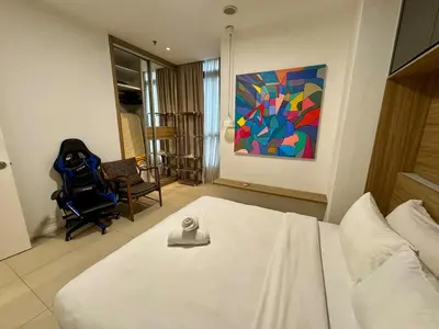 a bedroom with a bed and a chair and a painting at 1-5 people, Scandinavian Style Arcoris Mont Kiara in Kuala Lumpur