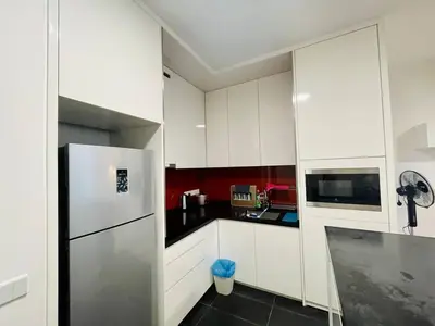 a kitchen with white cabinets and a stainless steel refrigerator at 1-5 people, Scandinavian Style Arcoris Mont Kiara in Kuala Lumpur