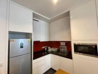 a kitchen with white cabinets and a refrigerator at Max 5pax, Muji Style Apartment Arcoris Mont Kiara in Kuala Lumpur