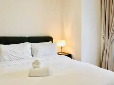 a white towel sitting on top of a white bed at Max 5pax, Muji Style Apartment Arcoris Mont Kiara in Kuala Lumpur