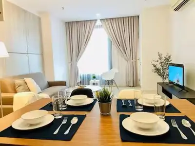 a living room with a table with plates and silverware at Max 5pax, Muji Style Apartment Arcoris Mont Kiara in Kuala Lumpur
