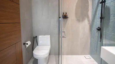 a bathroom with a toilet and a glass shower at Alfa Bangsar by Guestonic in Kuala Lumpur