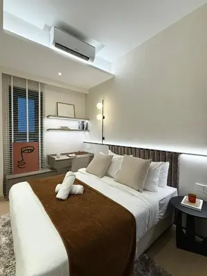 a bedroom with a large white bed with a brown blanket at Star Residence Heart of KLCC in Kuala Lumpur
