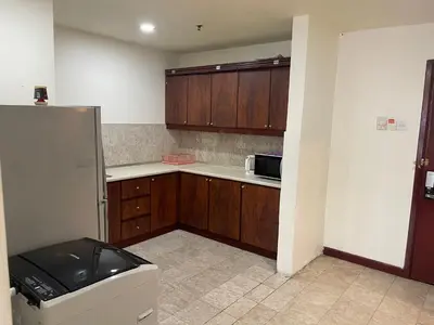 a kitchen with wooden cabinets and a refrigerator at Elegant Apartment at Times Square in Kuala Lumpur