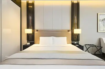 a bedroom with a large bed with two lamps at Bodhi Banyan Pavilion Kuala Lumpur by WSD in Kuala Lumpur