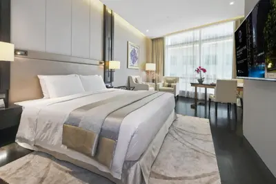 a bedroom with a large bed and a living room at Bodhi Banyan Pavilion Kuala Lumpur by WSD in Kuala Lumpur