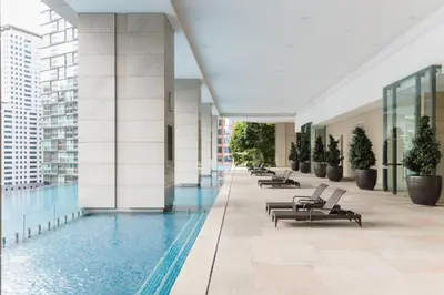 a building with a swimming pool and lounge chairs at Bodhi Banyan Pavilion Kuala Lumpur by WSD in Kuala Lumpur