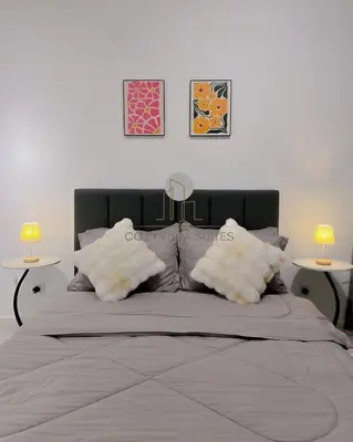 a bedroom with a large bed with two tables at Arte Mont Kiara by CozyVista Suites in Kuala Lumpur