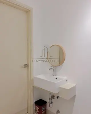 a bathroom with a sink and a mirror on the wall at Arte Mont Kiara by CozyVista Suites in Kuala Lumpur
