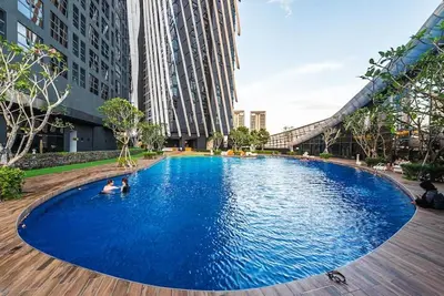 a large blue swimming pool in a city with buildings at Arte Mont Kiara by CozyVista Suites in Kuala Lumpur