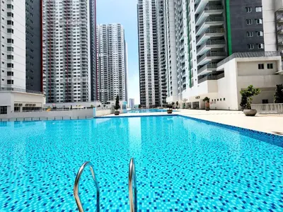 a large swimming pool with tall buildings in the background at RC Residence 6 pax by Define Suite in Kuala Lumpur