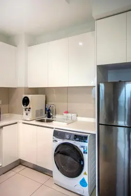 a kitchen with a washing machine in a white kitchen at Astoria Ampang Modern 2Bedroom Suite Free Parking in Kuala Lumpur