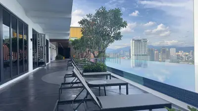 a building with a pool with tables and benches on it at Private family suite 1113A1BR at Majestic Residence in Kuala Lumpur