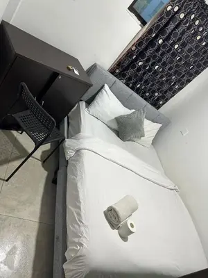 a bedroom with a white bed with a black headboard at Moonlight Inn Bukit Bintang in Kuala Lumpur