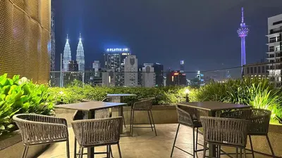 a patio with tables and chairs with a view of the city at Luxury suite 293A at KLCC in Kuala Lumpur