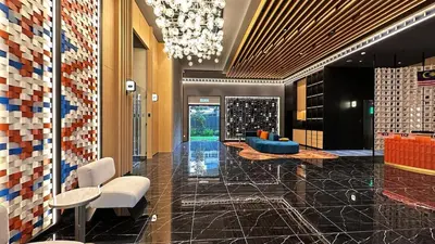 a lobby with a chandelier and a blue couch at Private family apartment 27131BR at Majestic Residence in Kuala Lumpur
