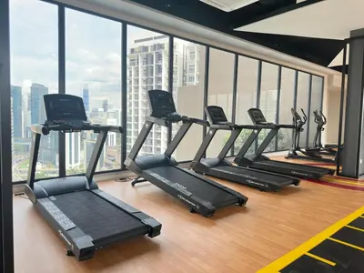 a row of treadmills in a gym with a large window at Luxury studio for couple 267B at KLCC in Kuala Lumpur