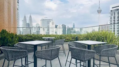 a patio with tables and chairs and a city skyline at Luxury couple suite 251B at KLCC in Kuala Lumpur