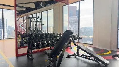 a gym with a lot of exercise equipment and windows at Private Family suite 23A13A1BR at KLCC in Kuala Lumpur
