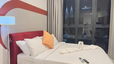 a white bed with a red headboard and a window at Cozy couple suite 272A at KLCC in Kuala Lumpur