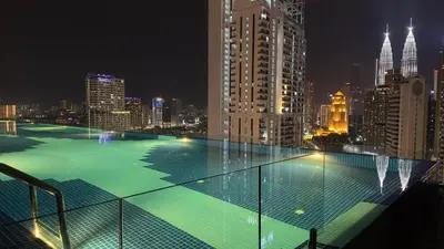 a large swimming pool on top of a building at night at Cozy couple suite 272A at KLCC in Kuala Lumpur