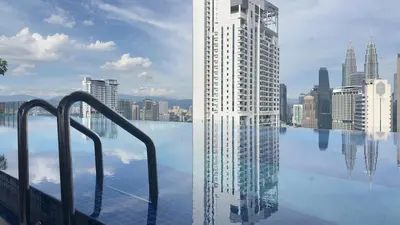 a swimming pool with a tall building in a city at Cozy couple suite 272A at KLCC in Kuala Lumpur