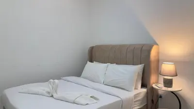 a bed with white sheets and towels on it at Private family suite 29171BR at KLCC in Kuala Lumpur