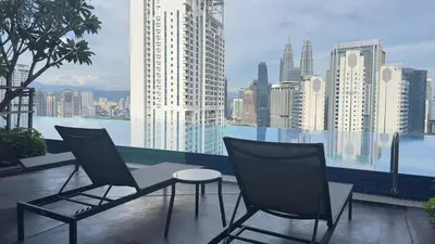 two chairs and a table on a balcony with a city at Luxury copule suite 232A at KLCC in Kuala Lumpur