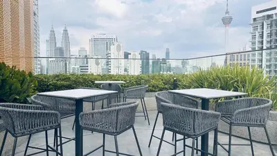 a group of tables and chairs on a patio with a city skyline at KLCC view couple stay 276A at KLCC in Kuala Lumpur