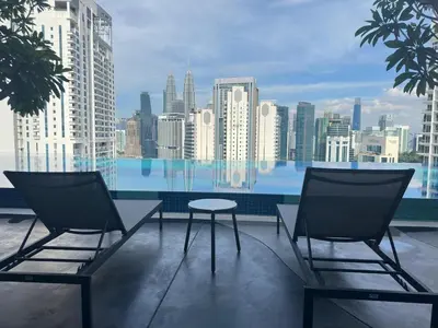 two chairs and a table on a balcony with a city skyline at KLCC view studio suite 272B at KLCC in Kuala Lumpur