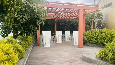 a pavilion with chairs and tables in a garden at Cozy suite for couple 297A at KLCC in Kuala Lumpur