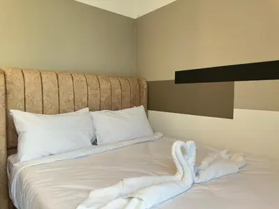 a bed with white towels on top of it at Private family suite 27171BR at KLCC in Kuala Lumpur